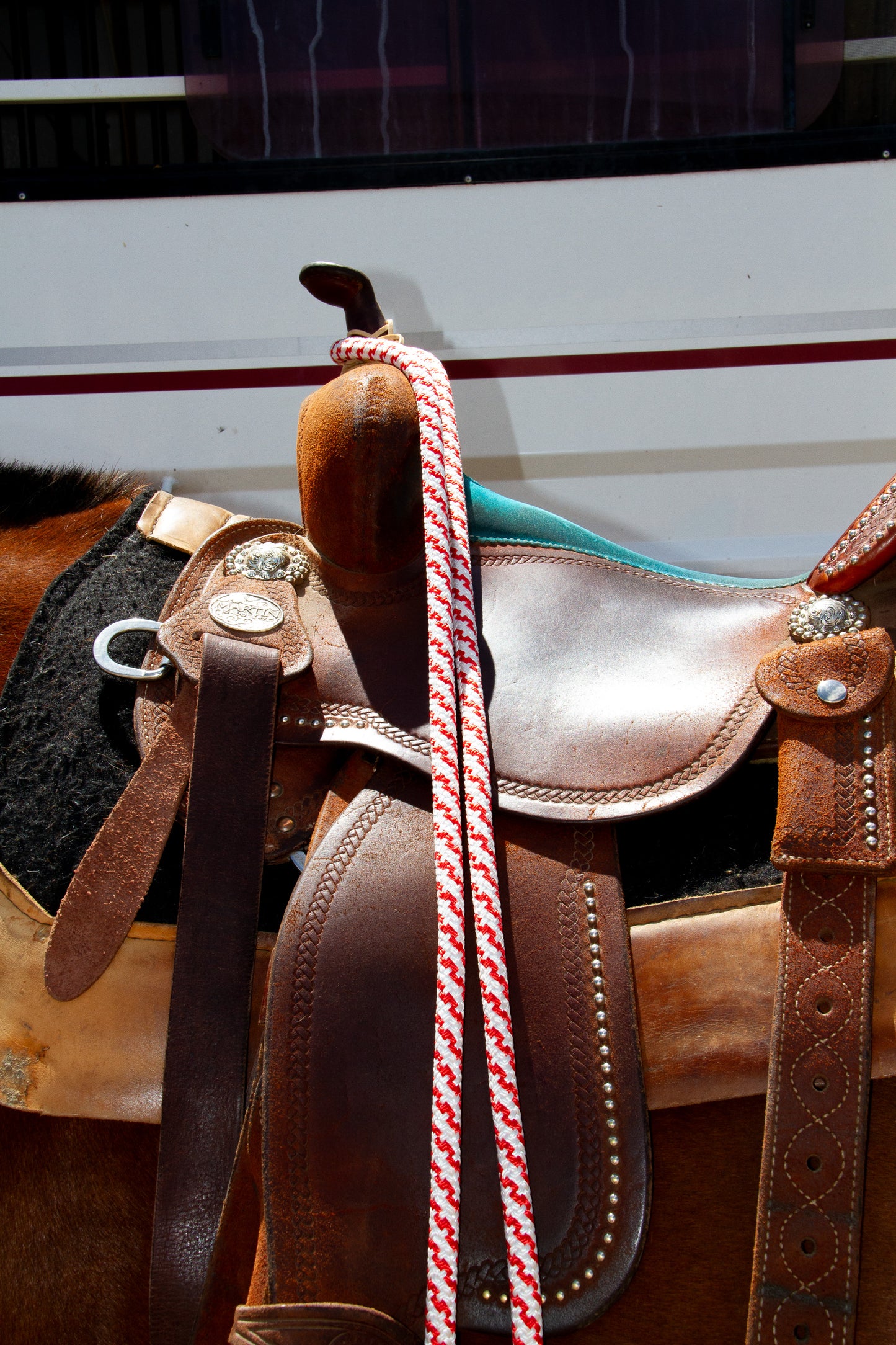 red and white rope reins on saddle