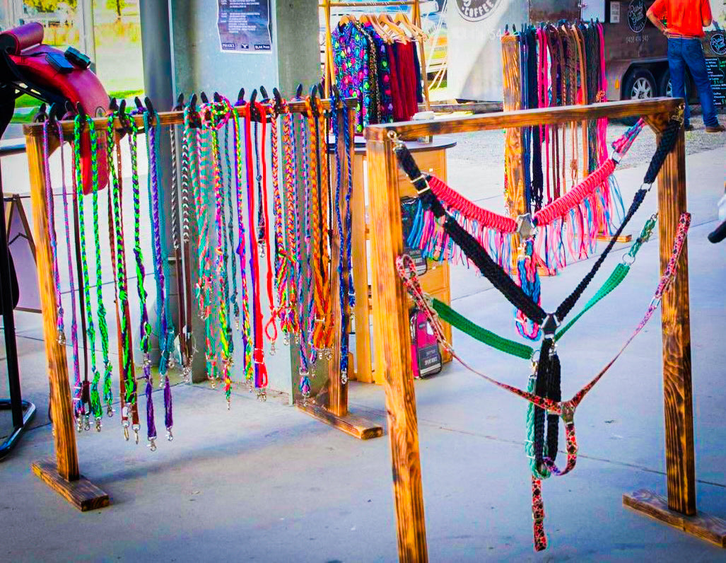 bright colourful reins and breast collars hanging on stands