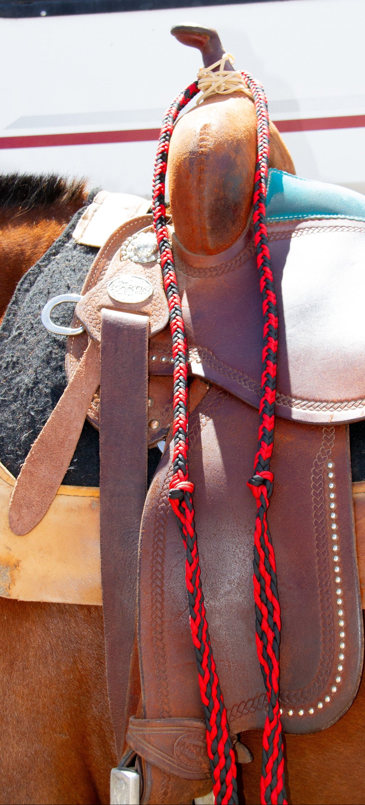 Close-up of a horse saddle with a red rope on a blurred background