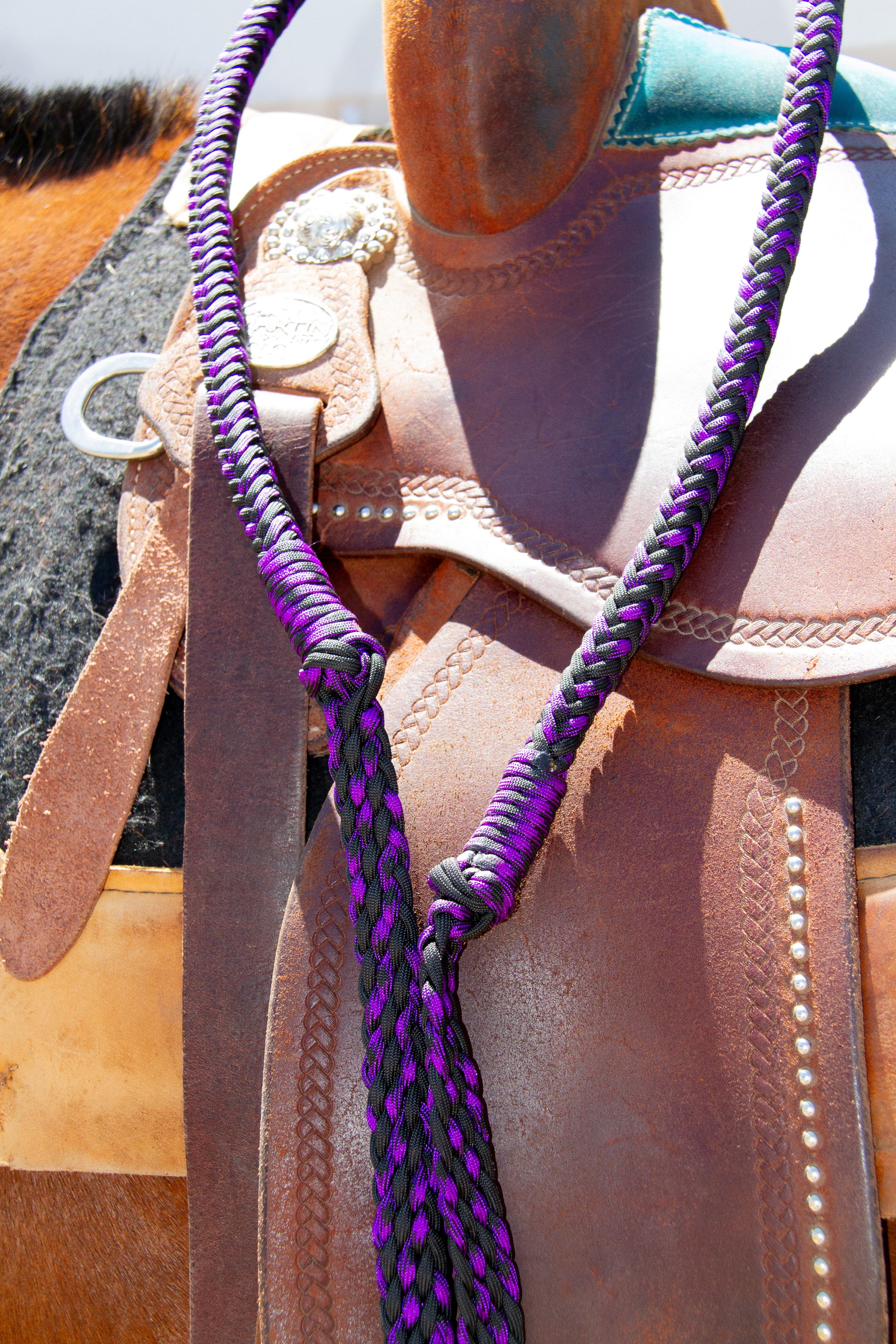 Close-up of a horse saddle with a purple reins