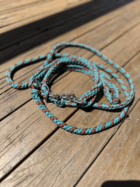 Slim, lightweight braided roping reins in turquoise and brown. 6–8ft long with trigger snaps and Conway adjustment. Perfect feel for little hands.