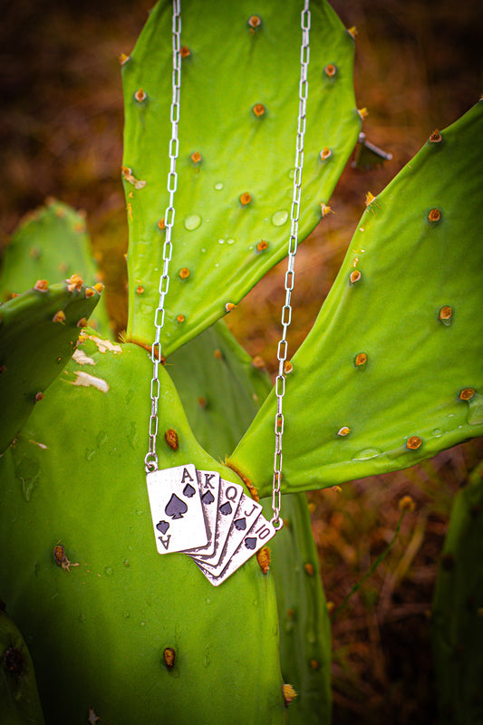 Necklace with royal flush playing card pendant on a cactus leaf