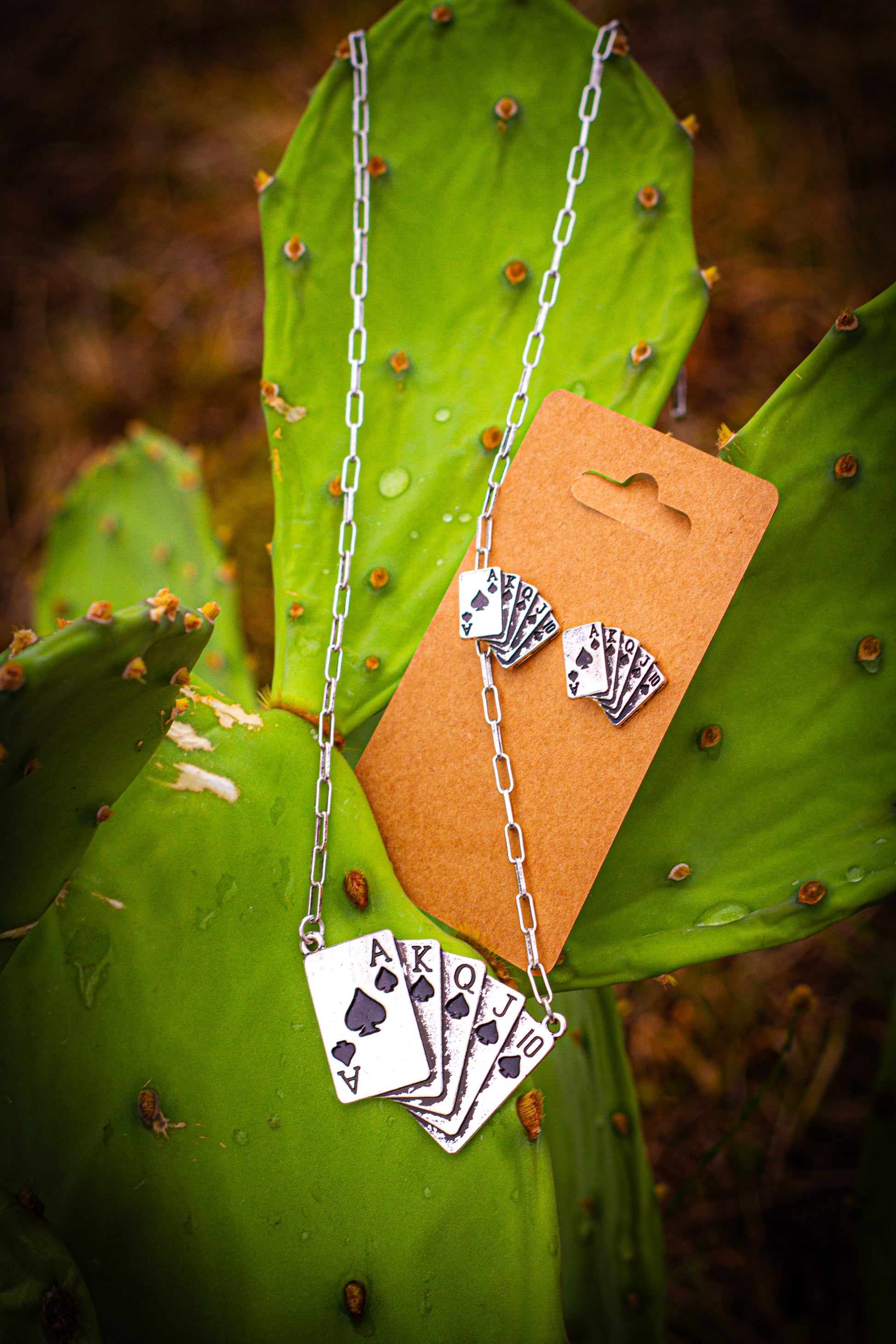 Necklace with royal flush playing card pendant on a cactus leaf