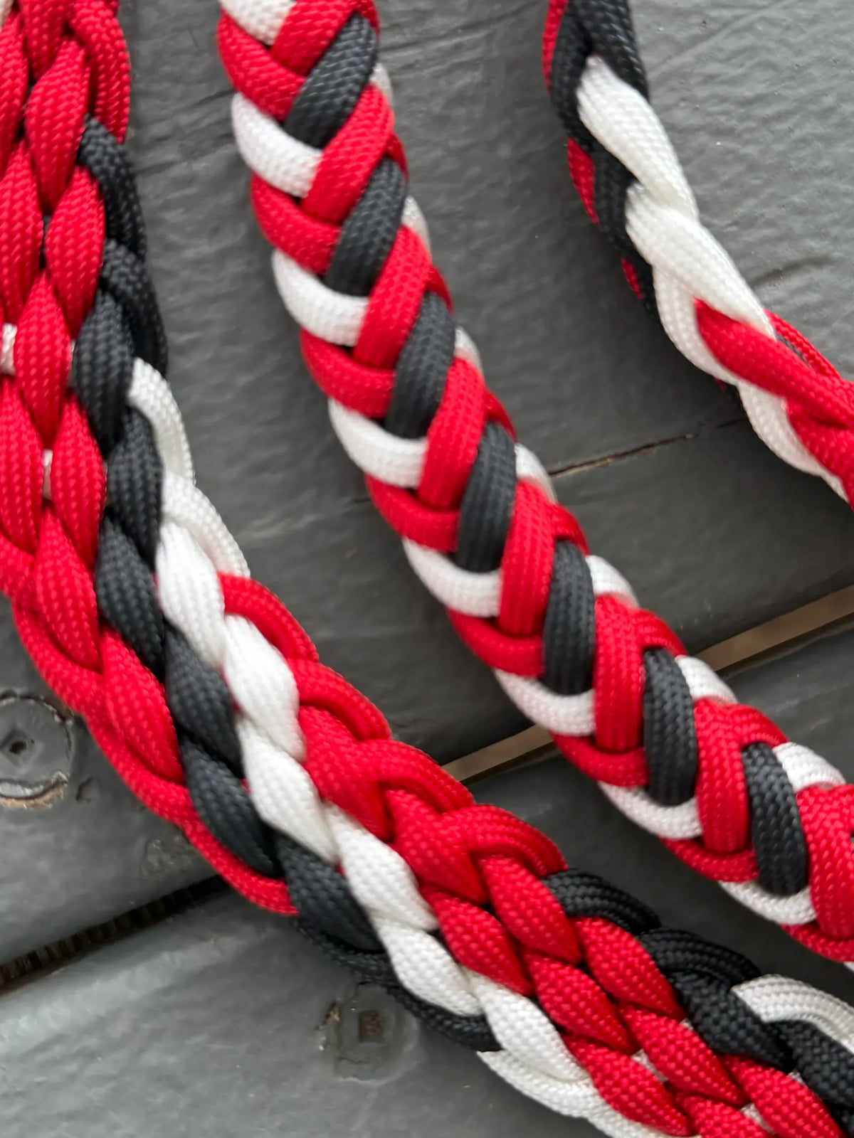 Detail of the round and flat hand-braided sections of black, white and red stabiliser reins
