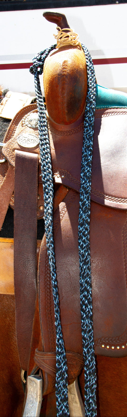 Close-up of a horse saddle with a split reins on a horse.
