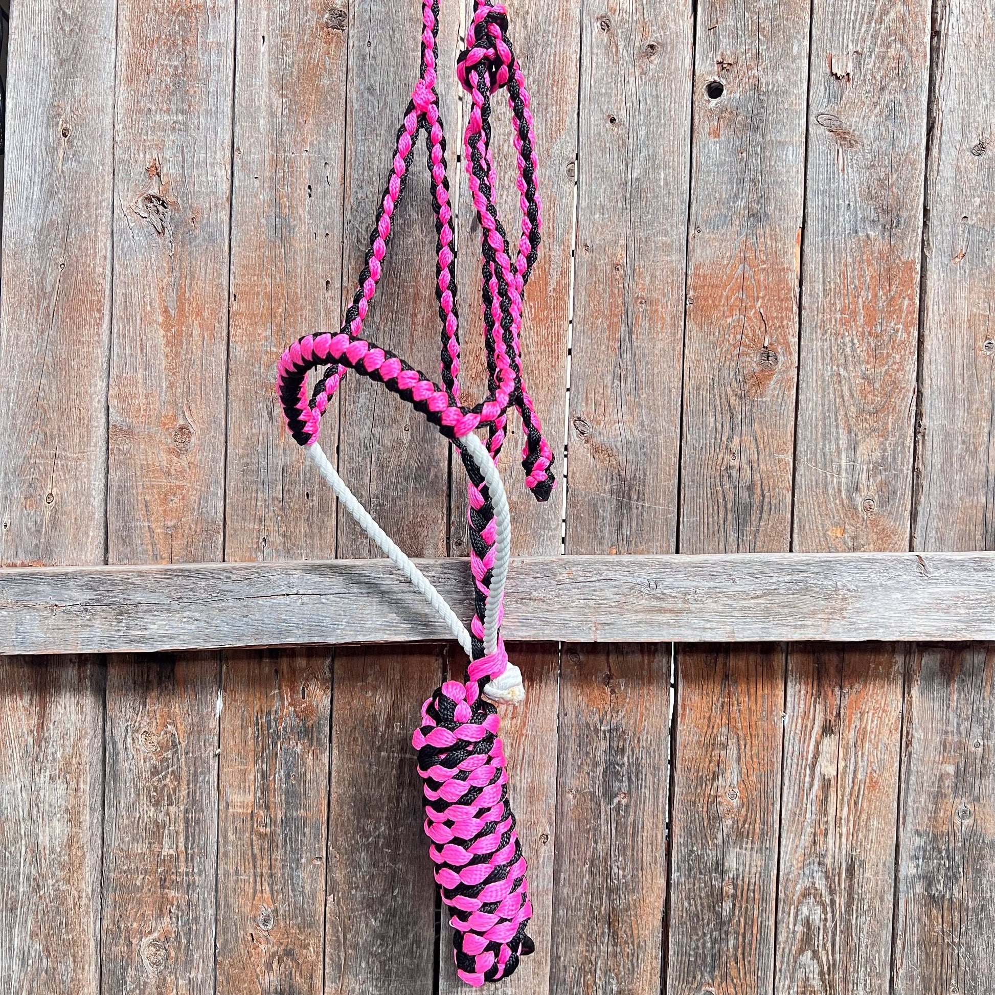 Pink and black braided rope against a wooden background